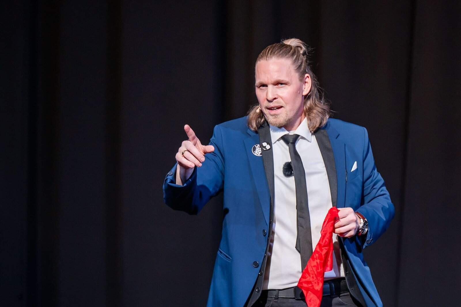 henry oz blue suit silk performance German magician Henry Oz on stage in a blue suit holding a red silk during a theater show in the San Juan Islands