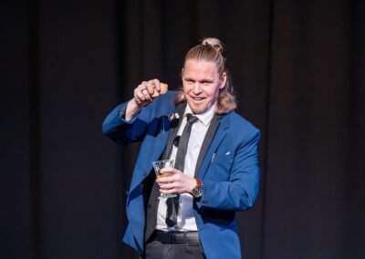 Henry Oz performing close up magic with an egg and glass during a live theater show on Lopez Island