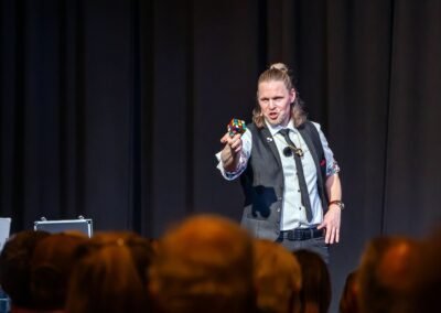 German magician Henry Oz with a Rubiks cube and hand on hip during a theater show on Lopez Island